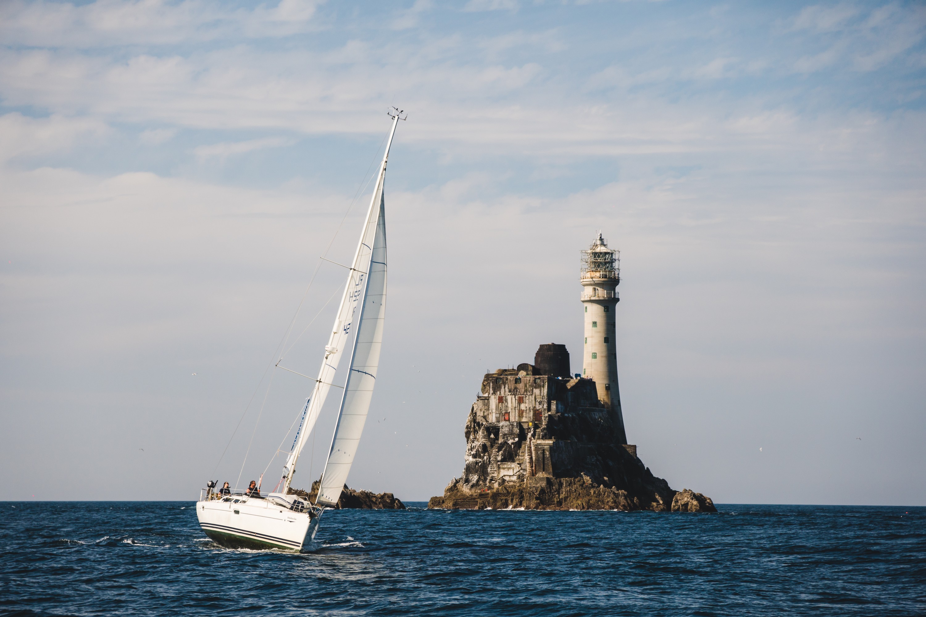 Un voilier aux abord du phare de Fastnet rock - © timursalikhov 