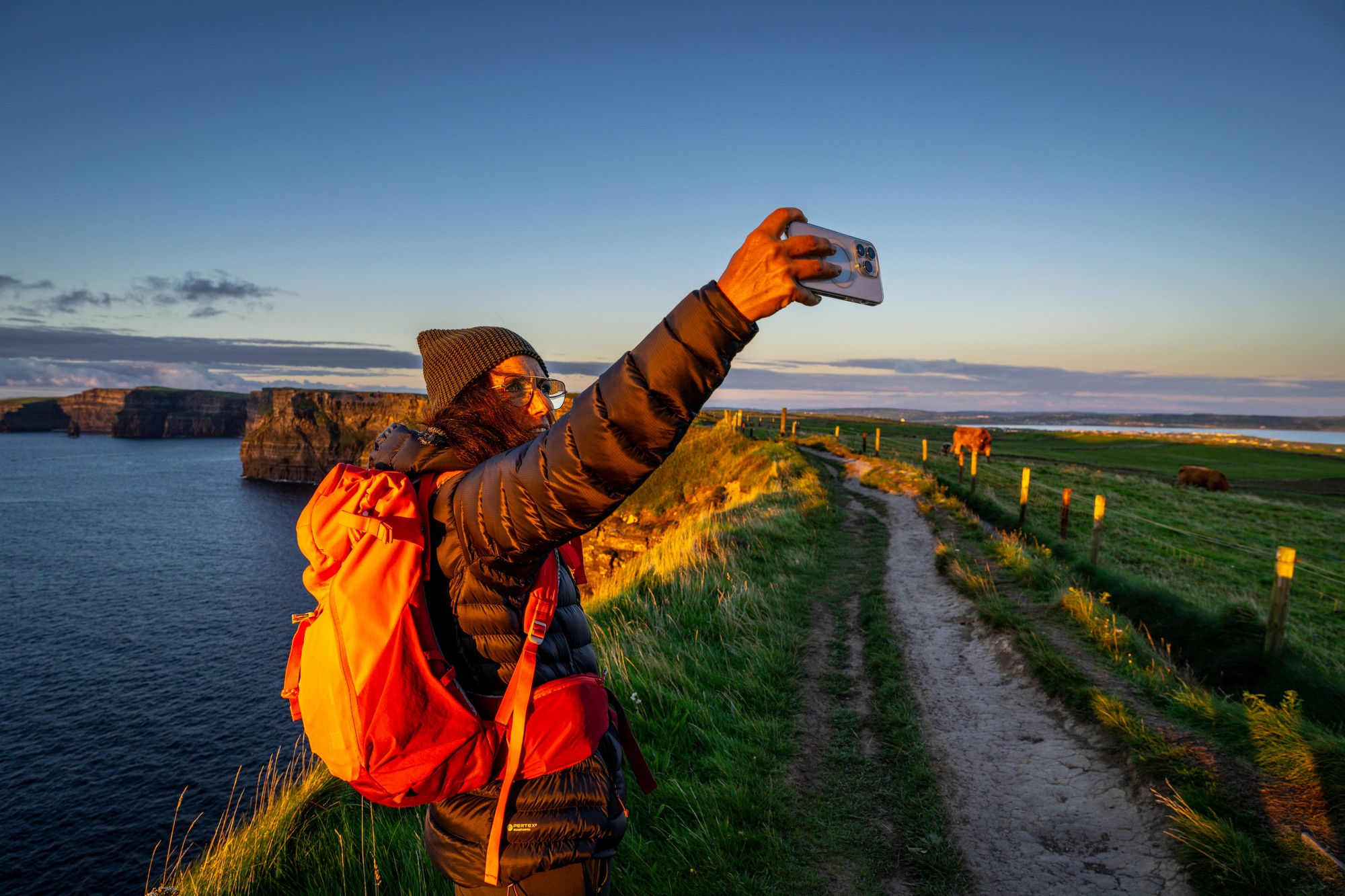 Une voyageuse prenant un selfie face aux Falaises de Moher - © Tolo 