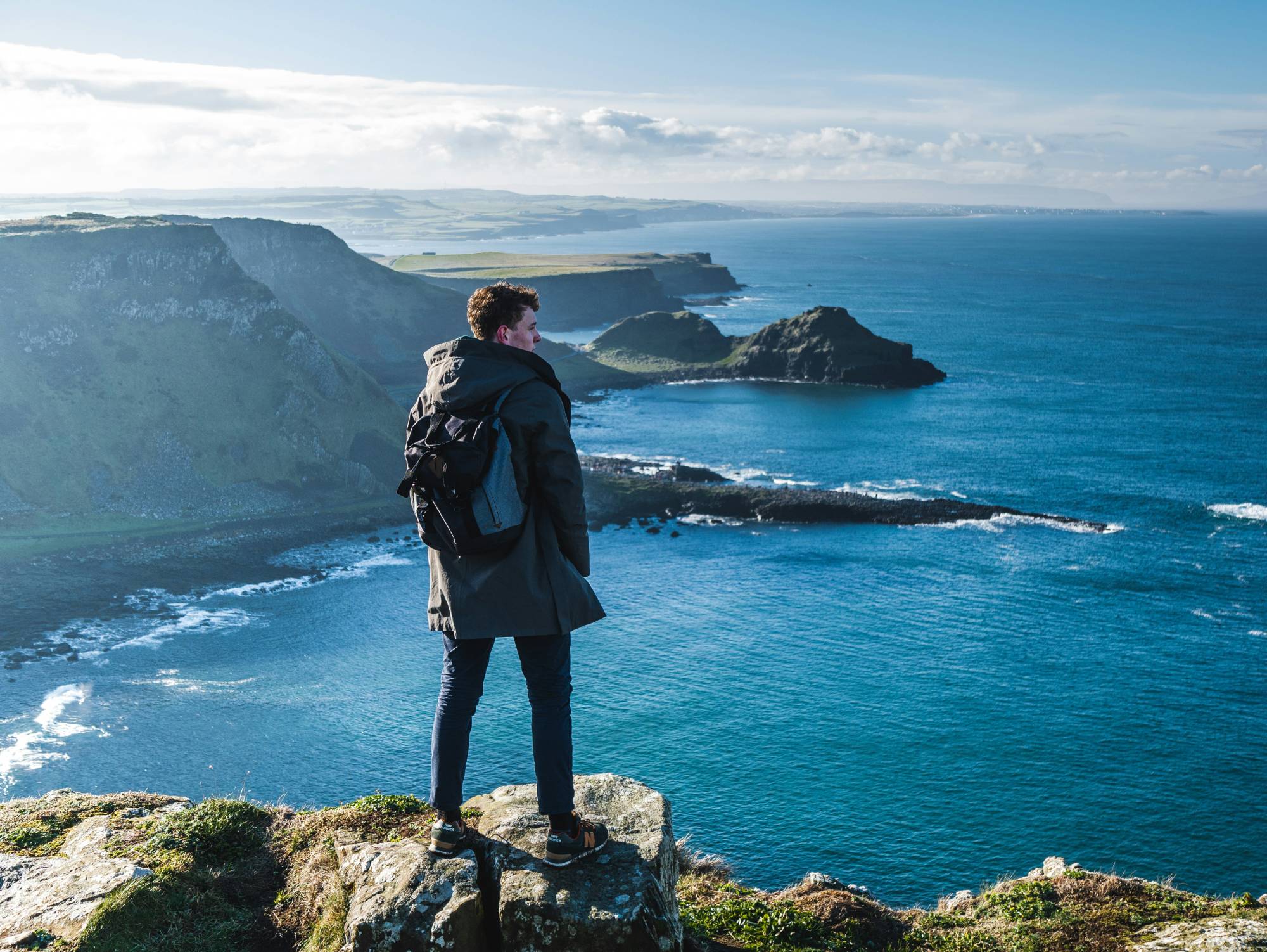 Un homme qui fait face à la vue sur la Chaussée des Géants - Felix Meynet sur Unsplash